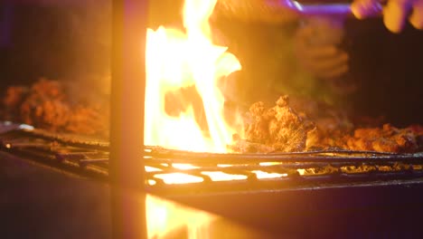 barbecuing beef on an outdoor grill at night