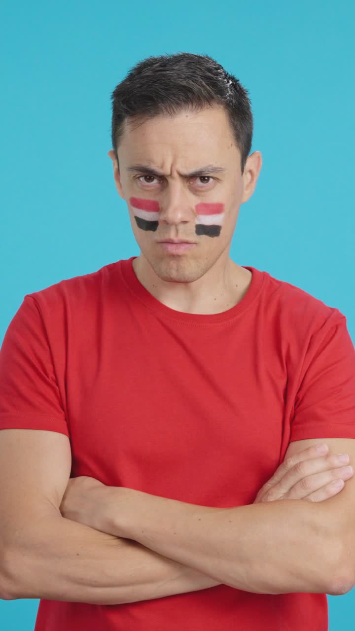 Dignified and serious man with egyptian flag painted on face