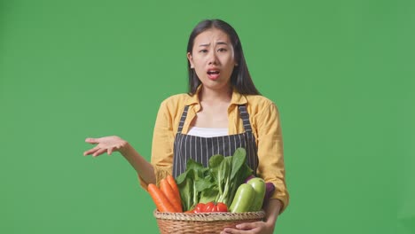 woman holding basket of vegetables