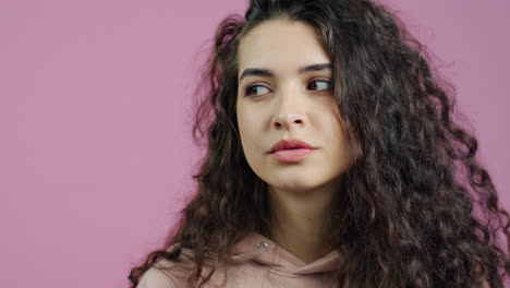 woman with curly hair on pink background