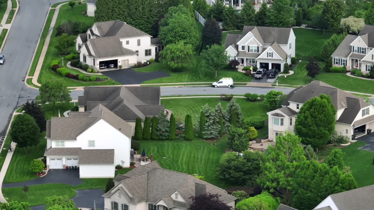 Quiet suburban neighborhood in US with single family homes, manicured lawns, trees and playground in garden. Aerial view. Typical peaceful residential area in United States. Peaceful neighborhood.