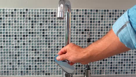 hand opening a water tap