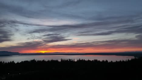 Drone-shot-pulling-away-from-a-beautiful-sunset-over-the-Pacific-Ocean