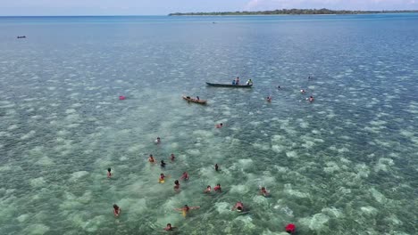 Hermosa-Vista-Aérea-Con-Niños-A-Los-Que-Les-Encanta-Jugar-Y-Nadar-En-El-Pueblo-De-Agua-De-Mar-De-Kampung-Bajau,-Sulawesi,-Cultura-Indonesia