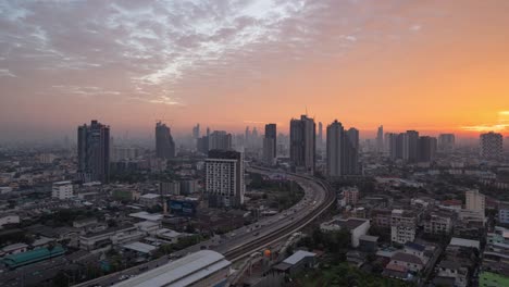 time lapse of aerial view of highway street road at bangkok downtown skyline, thailand. financial district and business centers in smart urban city in asia.skyscraper and high-rise buildings at sunset