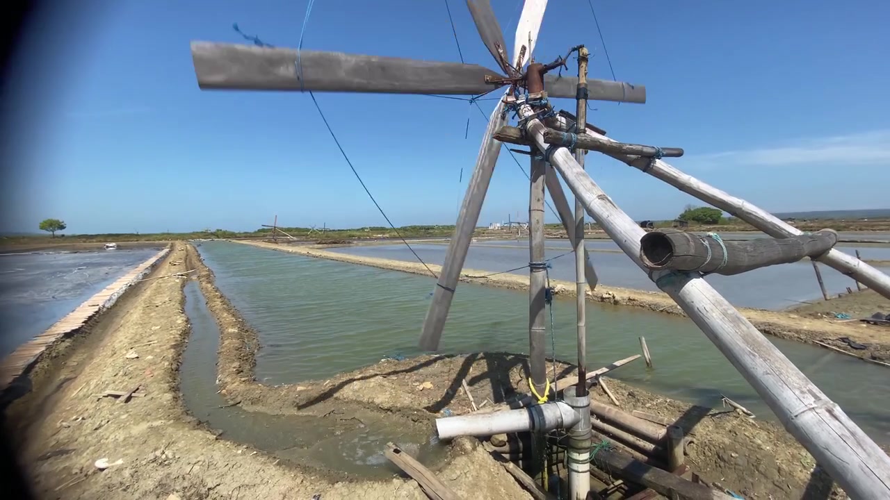 Mulino a vento tradizionale che pompa acqua per l'irrigazione di una salina.