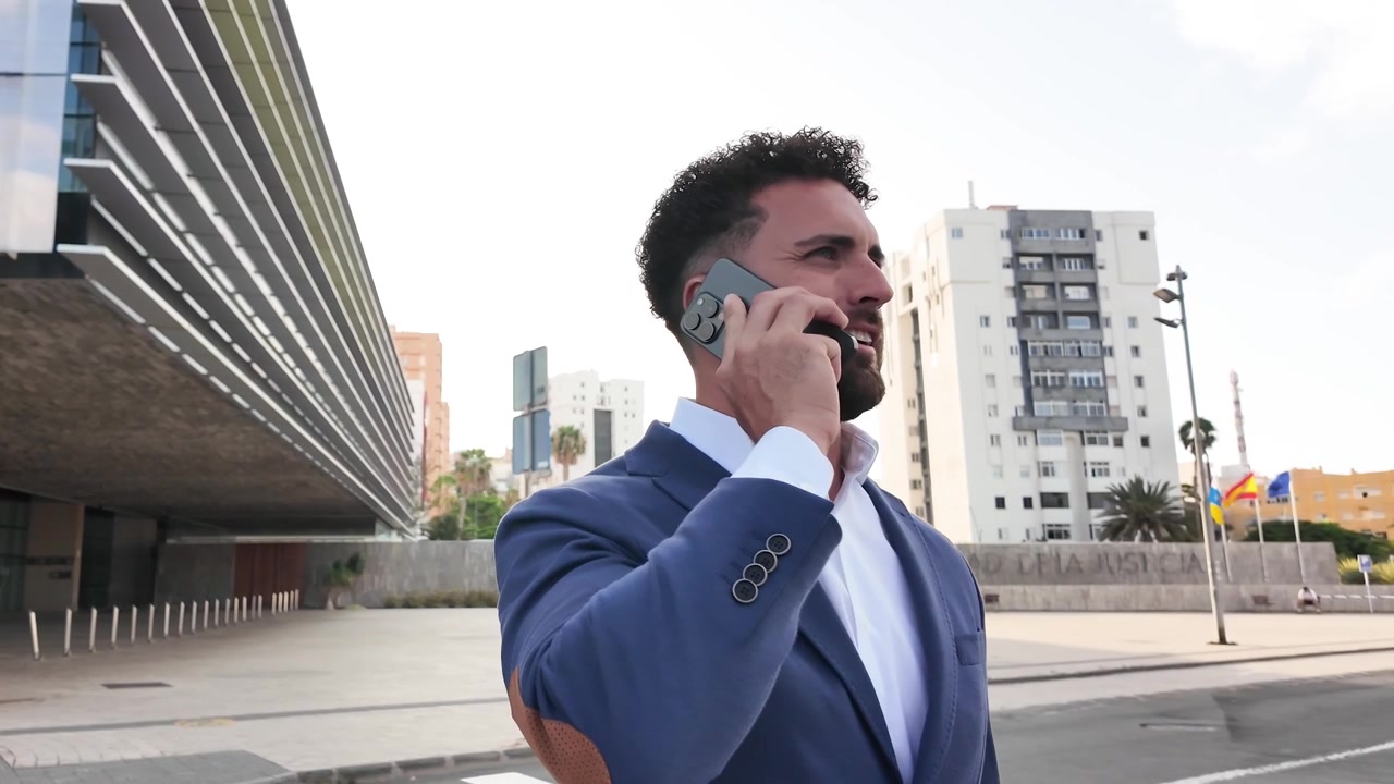 Uomo d'affari che parla al telefono fuori dall'edificio