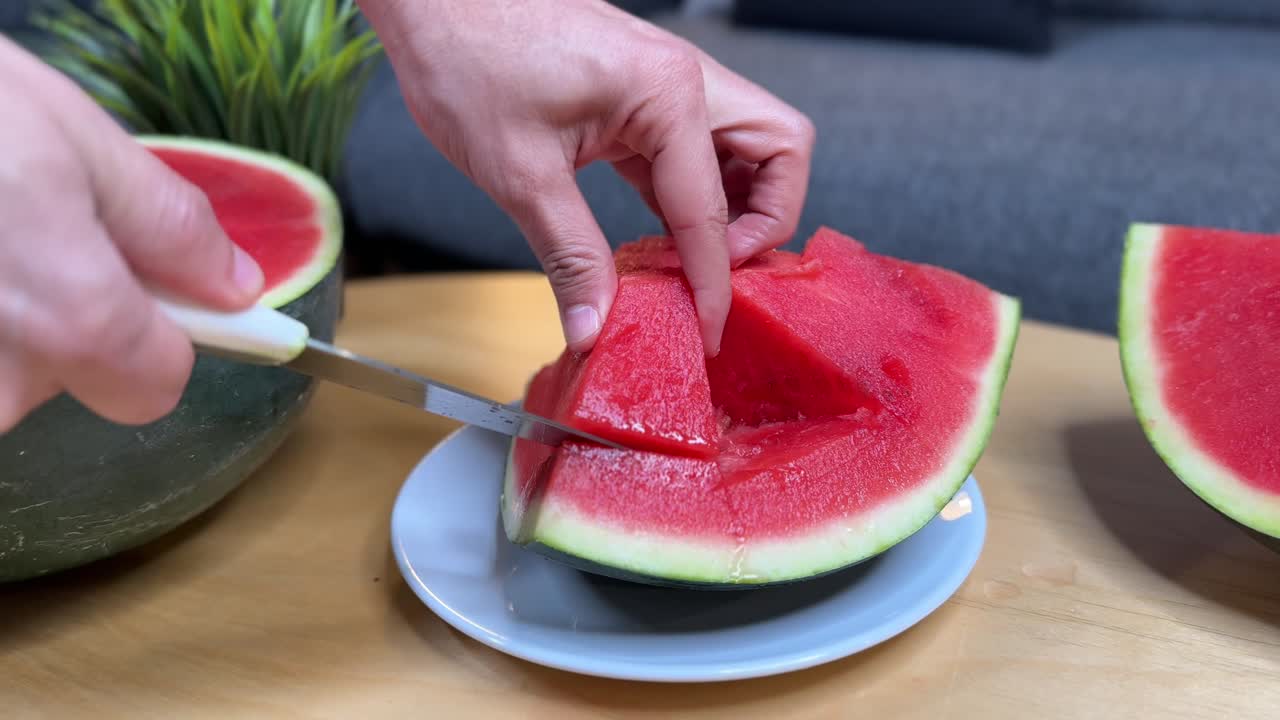 Close-up of a hand slicing fresh juicy watermelon on a plate, perfect for food, health, nutrition, summer refreshment, and lifestyle projects