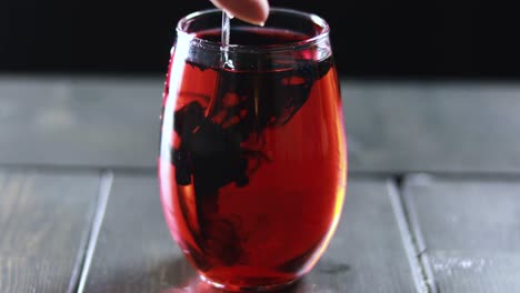 mezclando tinte azul en un vaso rojo