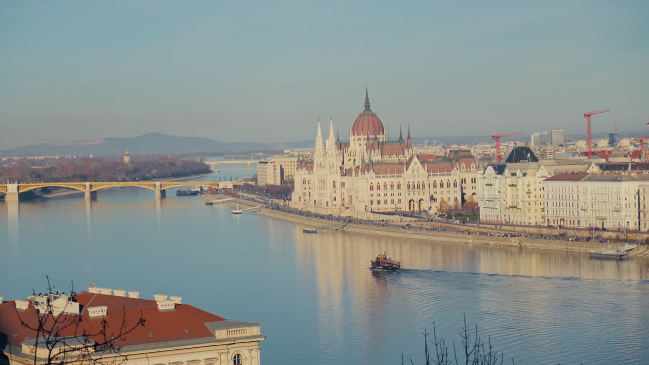 Ampia vista panoramica dell'edificio del Parlamento ungherese lungo il fiume Danubio a Budapest con una barca di passaggio