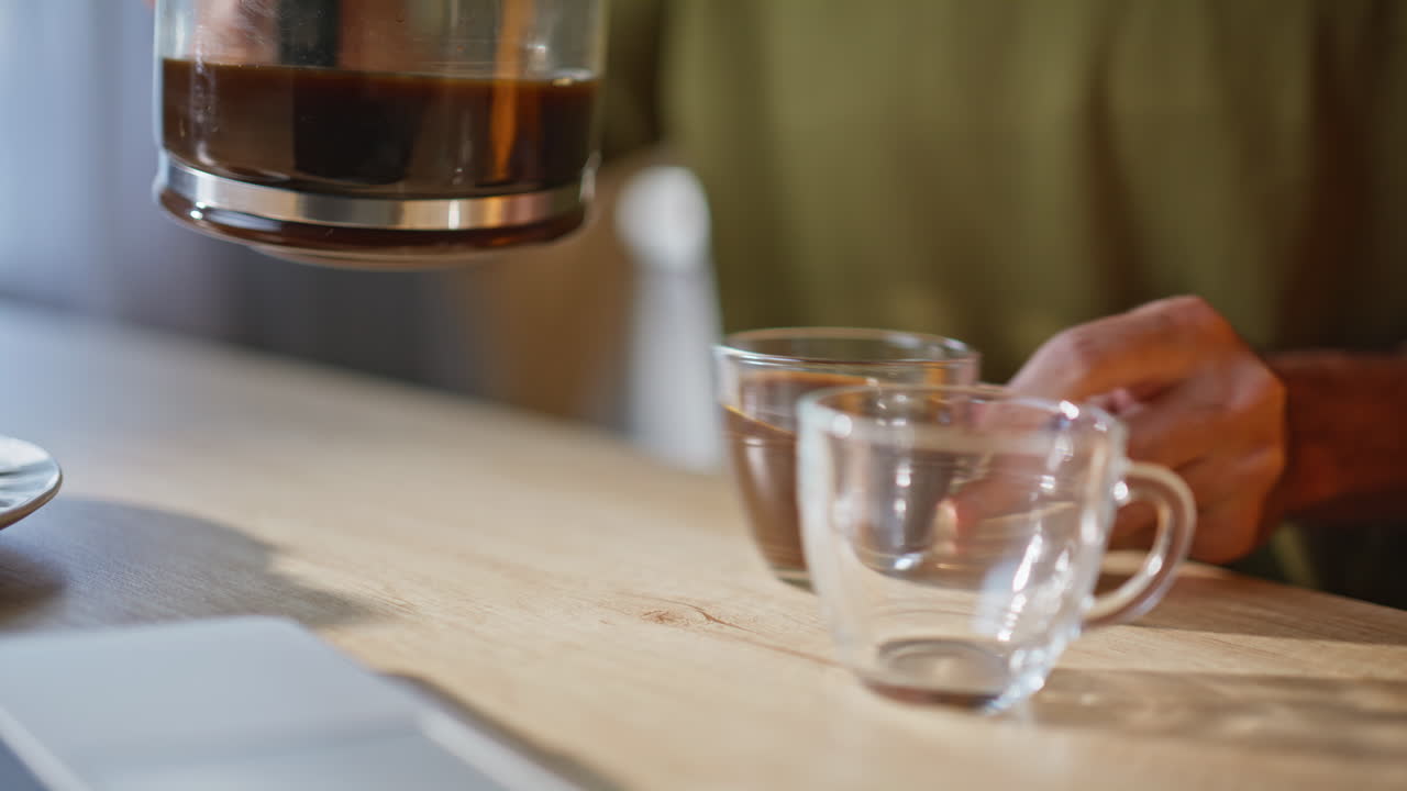 Boyfriend hands pouring espresso for girlfriend at apartment kitchen closeup