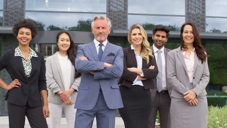 portrait of smiling multi-cultural business team outside modern office building