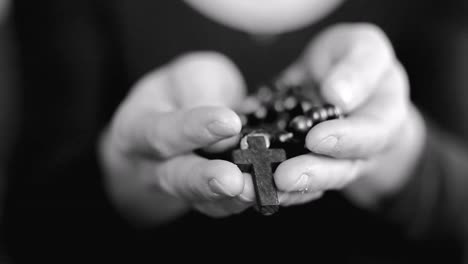 woman praying with hands together with cross on black background with people stock video