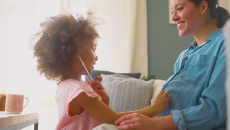 pregnant mother with daughter listening to baby heartbeat through stethoscope together