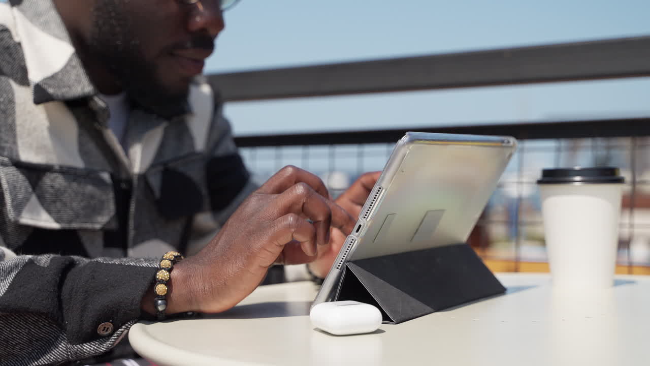 Man Using Tablet in Outdoor Cafe