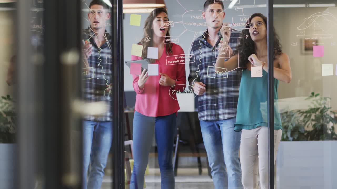 diversos colegas creativos en discusión haciendo notas en la pared de vidrio en la oficina, cámara lenta