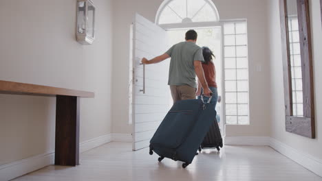 Family-With-Luggage-Opening-Front-Door-And-Leaving-For-Vacation