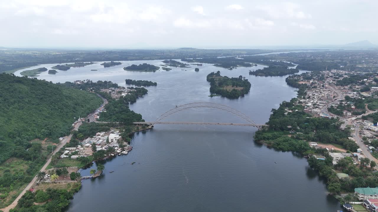 Ampio panorama con drone del Ponte Adomi sul fiume Volta ad Akosombo, Ghana. Veduta dall'alto dell'infrastruttura dell'Africa Occidentale, rigogliose sponde fluviali tropicali e un suggestivo paesaggio naturale.