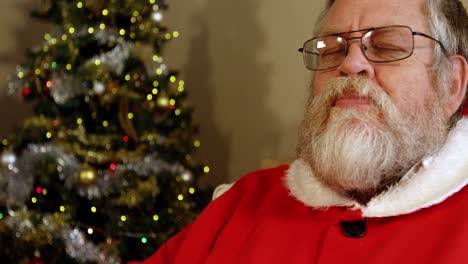 Santa-claus-relaxing-on-chair-having-sweet-food-and-drinking-milk