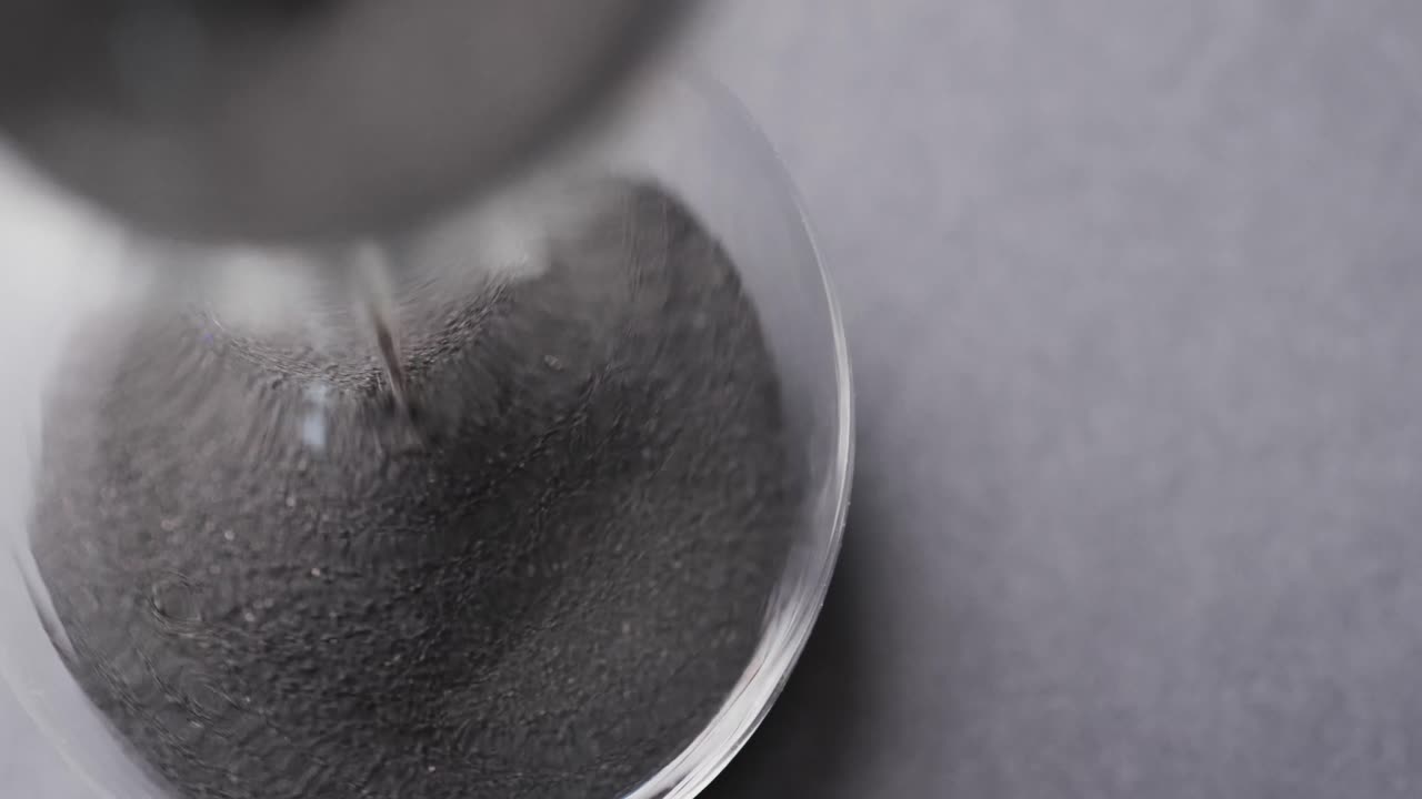 모래 를  ⁇ 는 모래 시계 의 클로즈업 영상, 회색 배경 에 있는 공간 을 복사