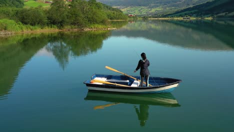 woman on the boat catches a fish on spinning in norway.