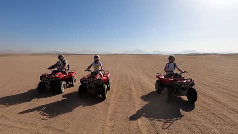 a family rides quad bikes in the desert. quad bike tour in the desert