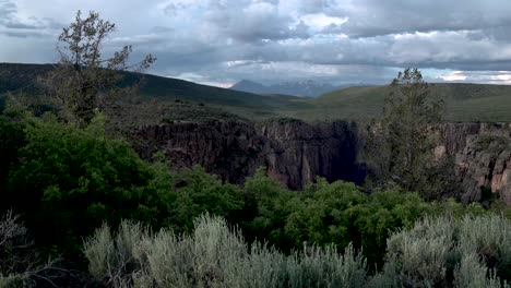 Felsige-Berge-Mit-Grasbewachsener-Ebene-In-Der-Nähe-Einer-Canyon-schlucht-In-Colorado-Usa,-Aufsteigende-Enthüllungsaufnahme-Des-Sockels