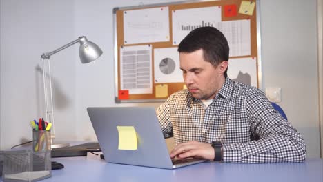 hombre trabajando en una computadora portátil en la oficina mientras vapea