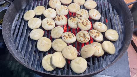 video of a street hawker in kolkata tossing litti over charcoal in an iron grill to cook it evenly