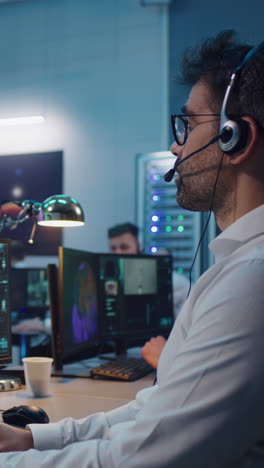 Anonymous-flight-director-in-suit-walking-towards-big-screen-with-astronaut-during-remote-spacecraft-launch-in-control-center.-Vertical-shot.