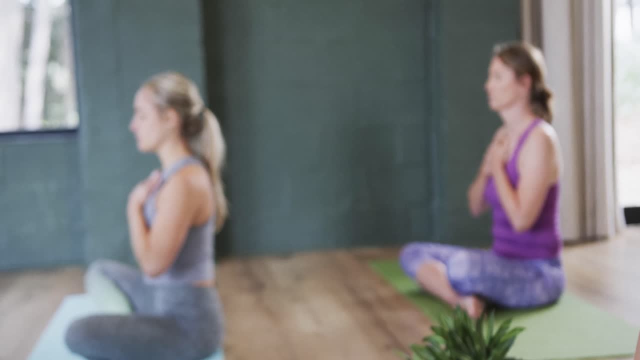 요가 스튜디오 에서 호흡 운동 을 연습 하는 가 ⁇  에 손 을  ⁇ 은 다민족 여성 들