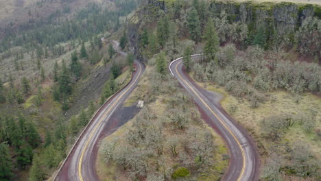 aerial view of scenic winding roads in a mountainous forest landscape