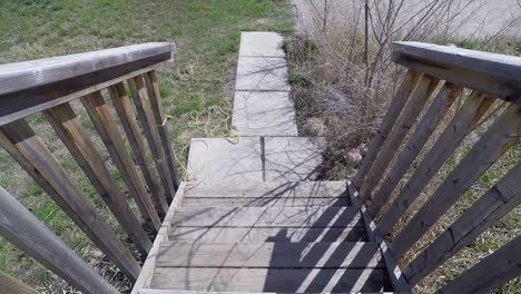 Standing-on-wooden-steps-at-the-front-door-of-a-home-looking-up-at-a-field-and-abandoned-building-across-the-street-in-the-summer