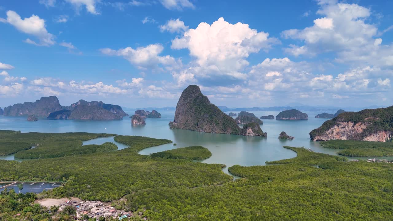Drone footage captures stunning aerial views of Phang Nga Bay's limestone cliffs and turquoise waters under a bright, clear sky