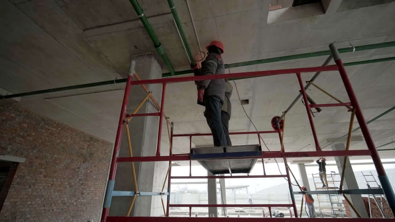 los trabajadores profesionales instalan tuberías de alcantarillado o de suministro de agua en una fábrica moderna. construcción de una fábrica, hangar