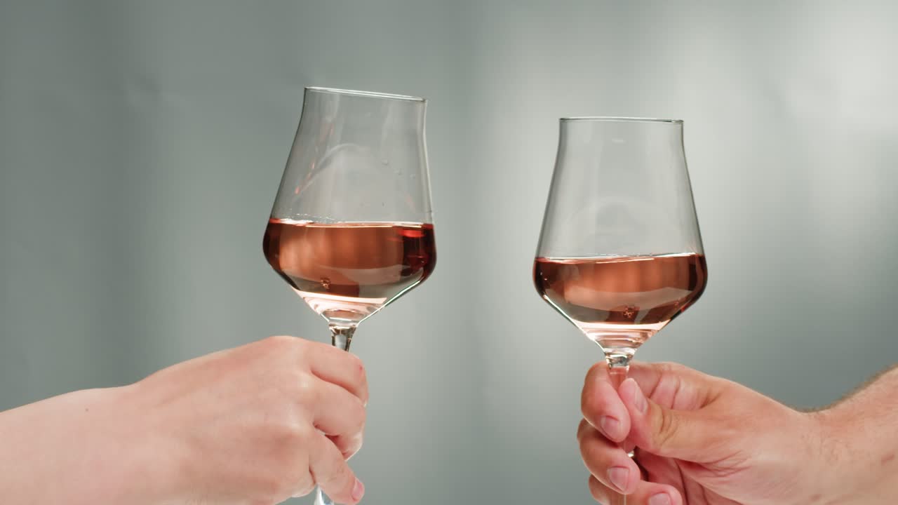 Rose Orange or white wine bottle and glass against a sunset in a peaceful vineyard, pouring of ecological natural wine. Cheers, hands with wine glasses, drinking alcohol.