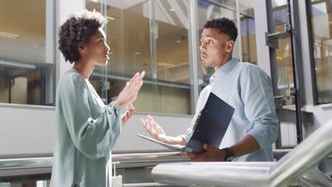 video of diverse businessman and businesswoman talking in office