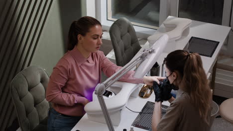 woman getting a manicure in a nail salon