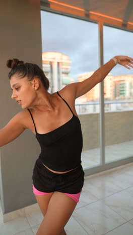 young woman stretching and posing on balcony