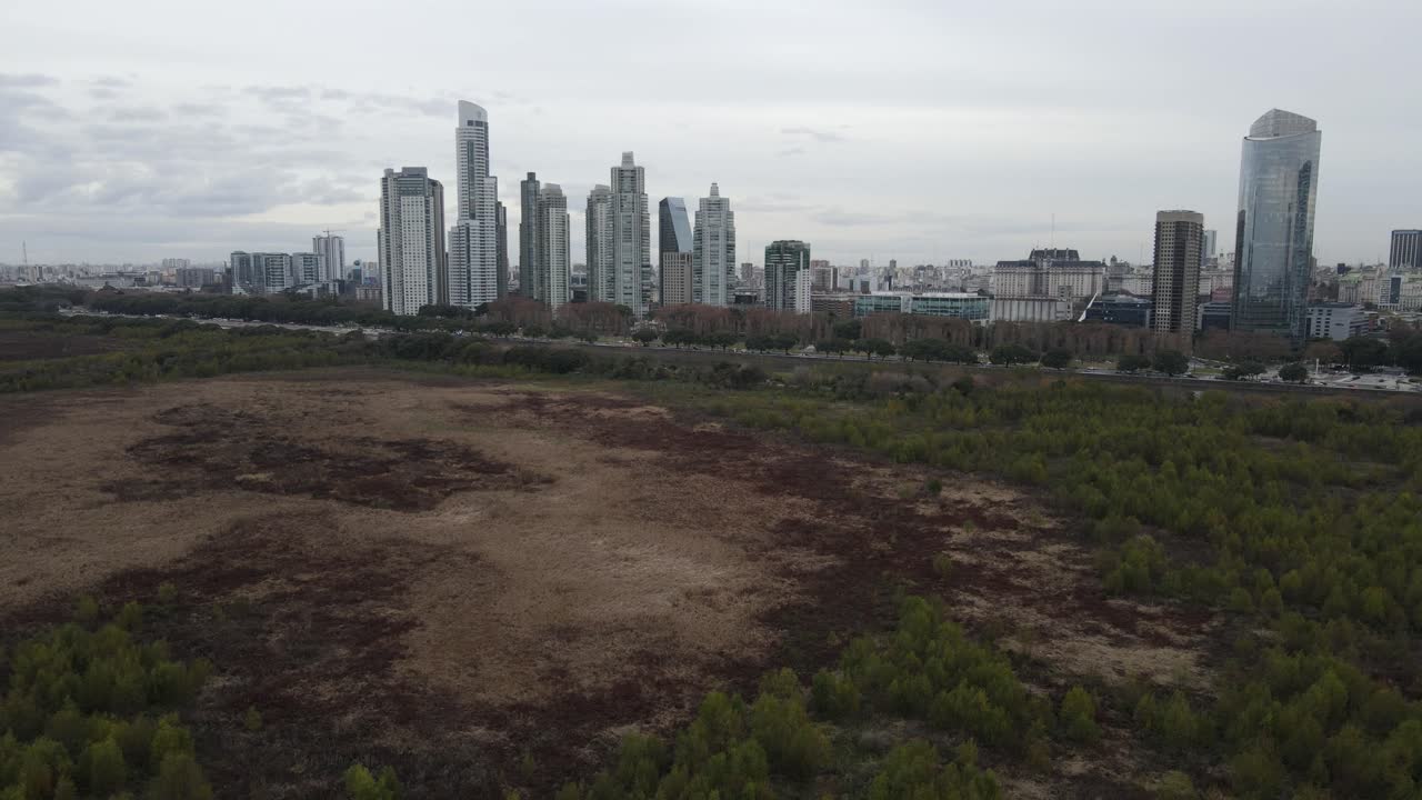 vista desde un parque con vegetación hacia una zona de la ciudad de buenos aires, argentina, con imponentes edificios