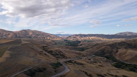 Aerial---winding-mountain-road-in-rugged-highlands-of-south-Island,-New-Zealand