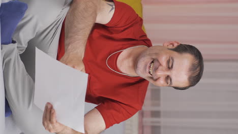 vídeo vertical del hombre que se regocija en el buen contenido del papeleo.