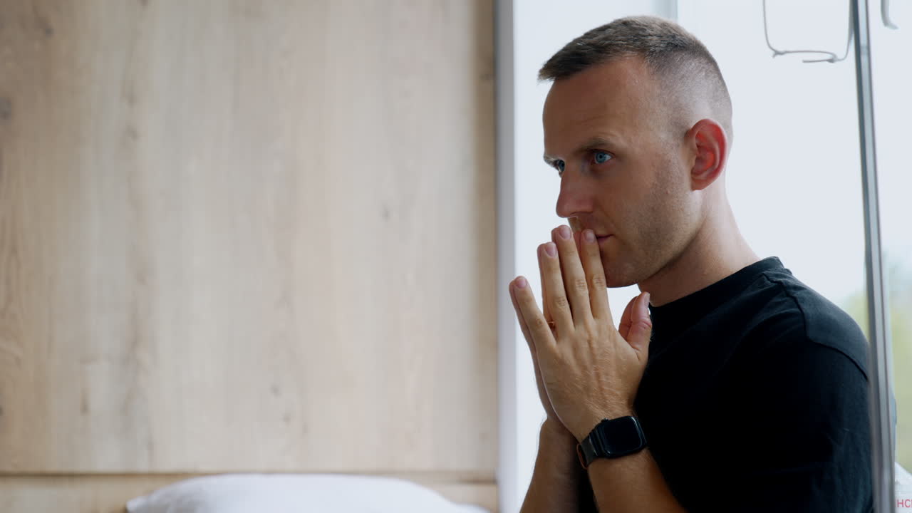 Tensed Caucasian man standing in the hospital ward. Worried husband during childbirth.