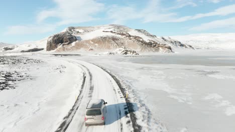 Eine-Kamerafahrt-Für-Ein-Graues-Auto,-Das-Mitten-Im-Schnee-Fährt