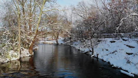 aerial sunrise view of rushing creek in winter forest in michigan