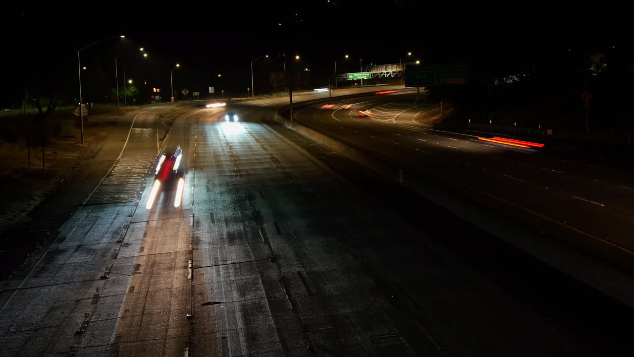 Headlights and taillights paint vivid trails across Oakland’s freeway, capturing the pulse of the city after dark.