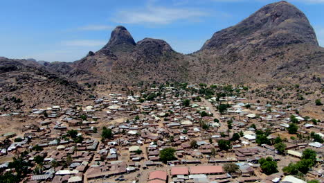 the nigerian city of dass beneath the rugged mountains of the bauchi state - push forward aerial view