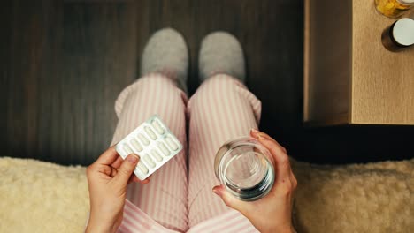 mujer tomando medicamentos en pijama