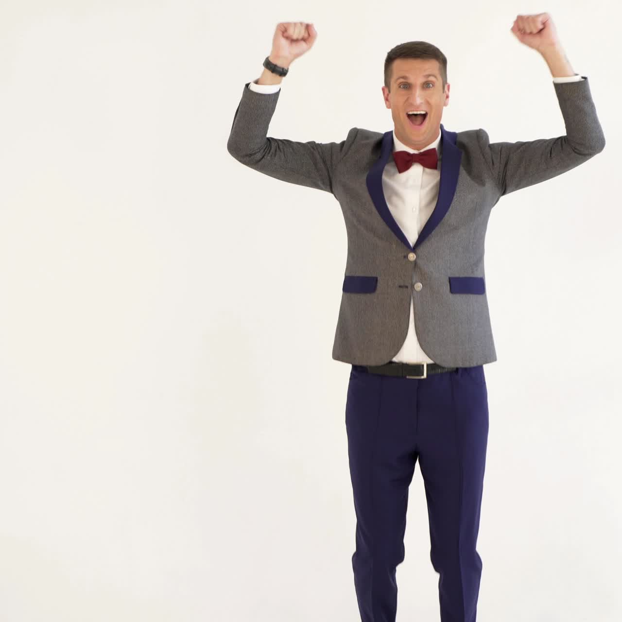 fun showman in trendy costume is parodying a man playing table tennis on a white background in the studio
