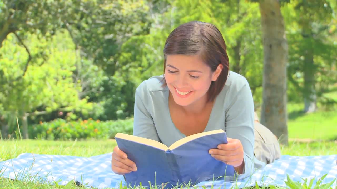 Young woman reading a book outside